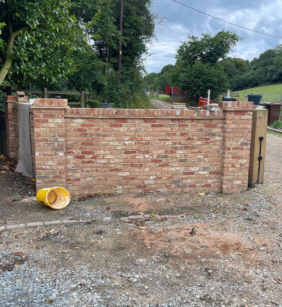 Completed boundary wall with dentil coping viewed from the road