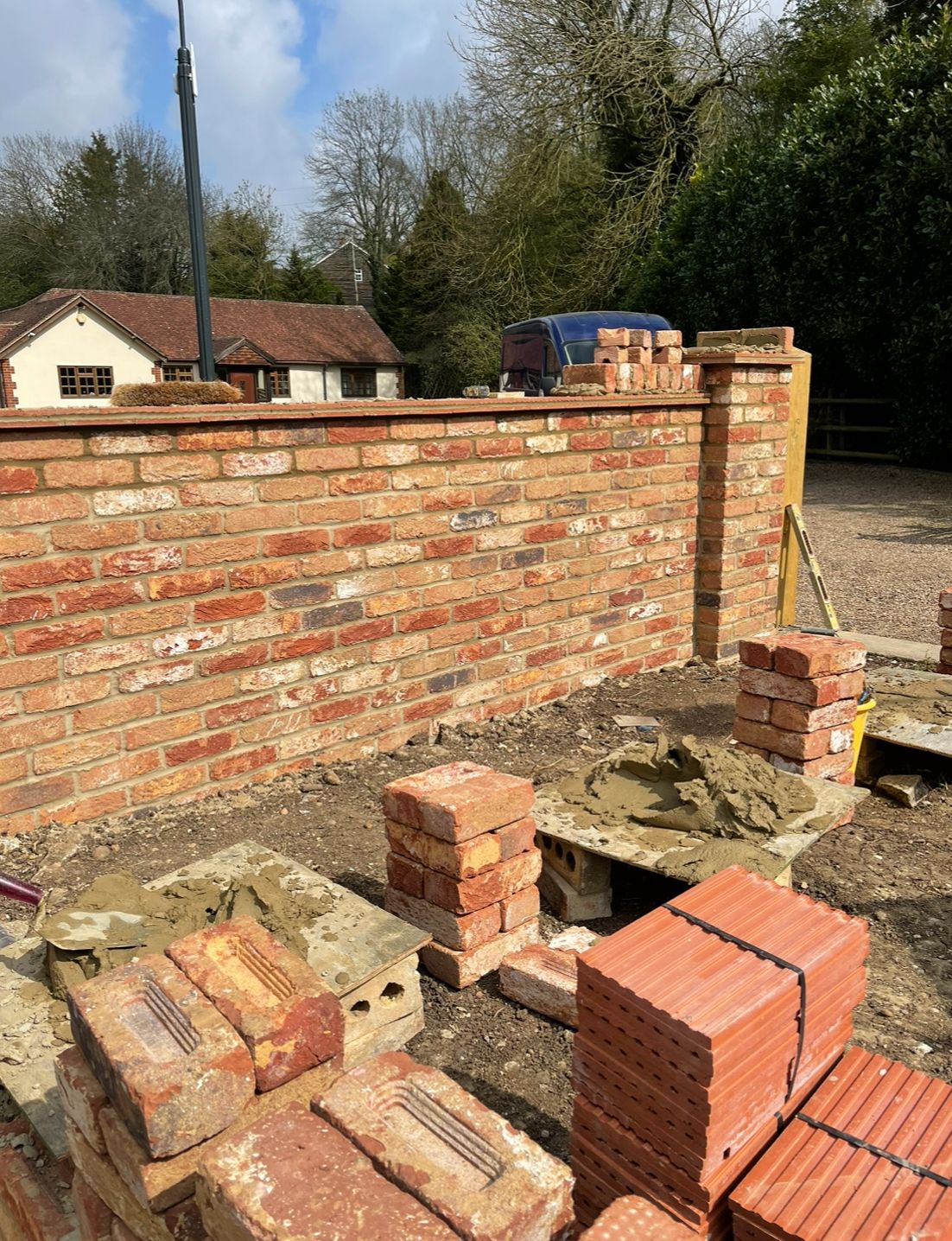 Reclaimed brick boundary wall with piers in a village setting