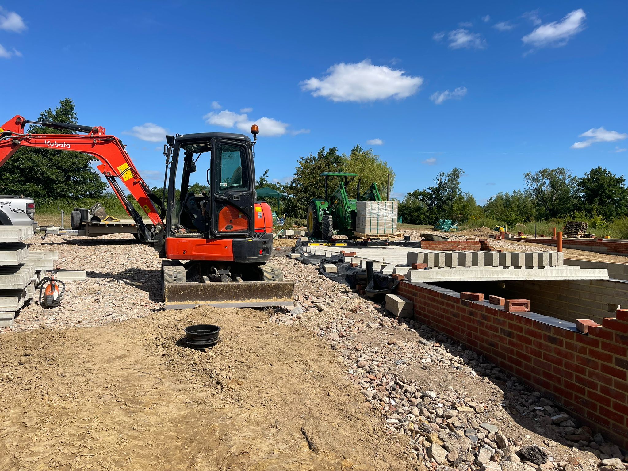 New build site with digger and brick foundations