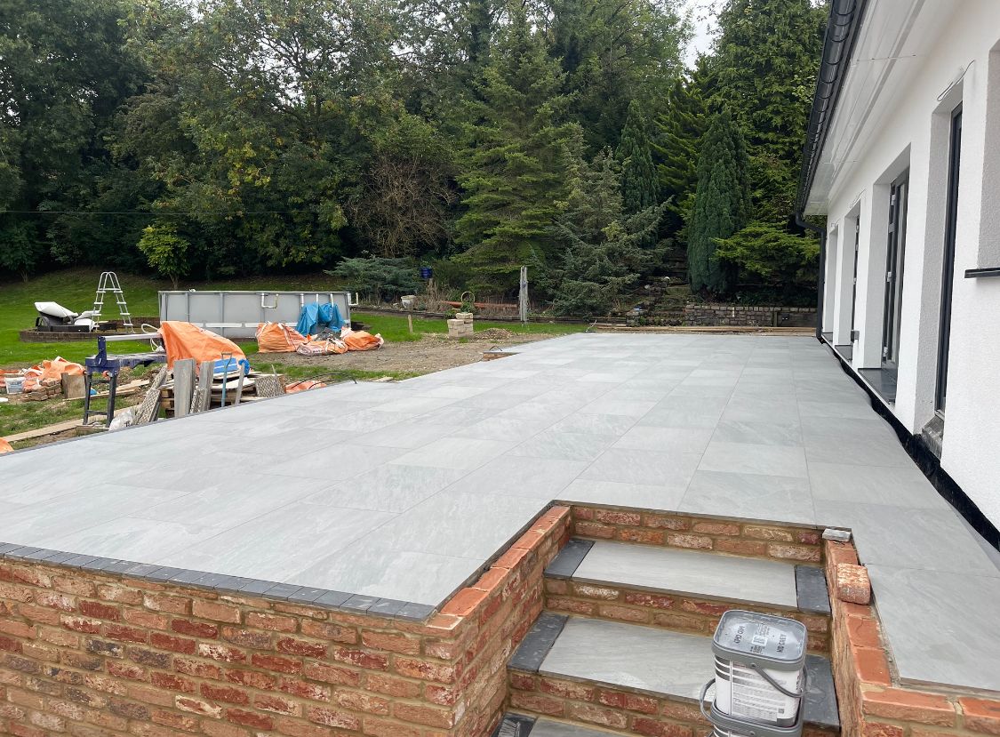 Porcelain patio with brick retaining wall and steps