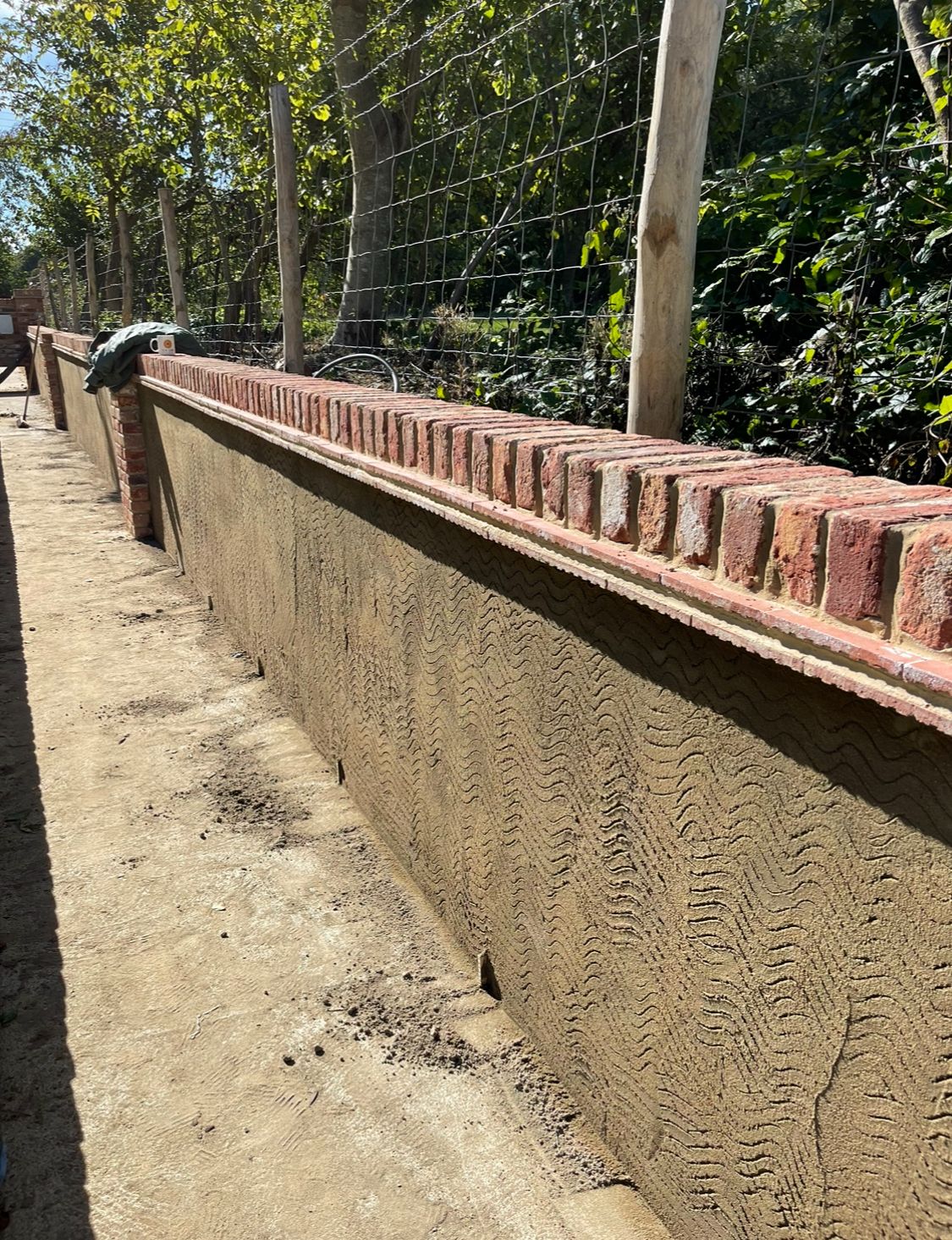 Rendered retaining wall with brick-on-edge coping