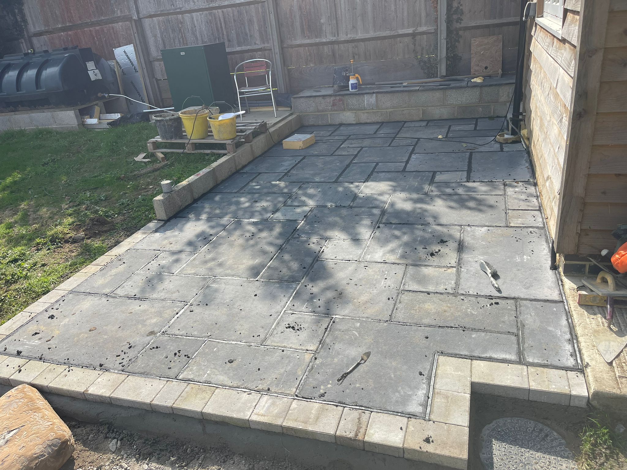 Completed dark slate patio with block edging