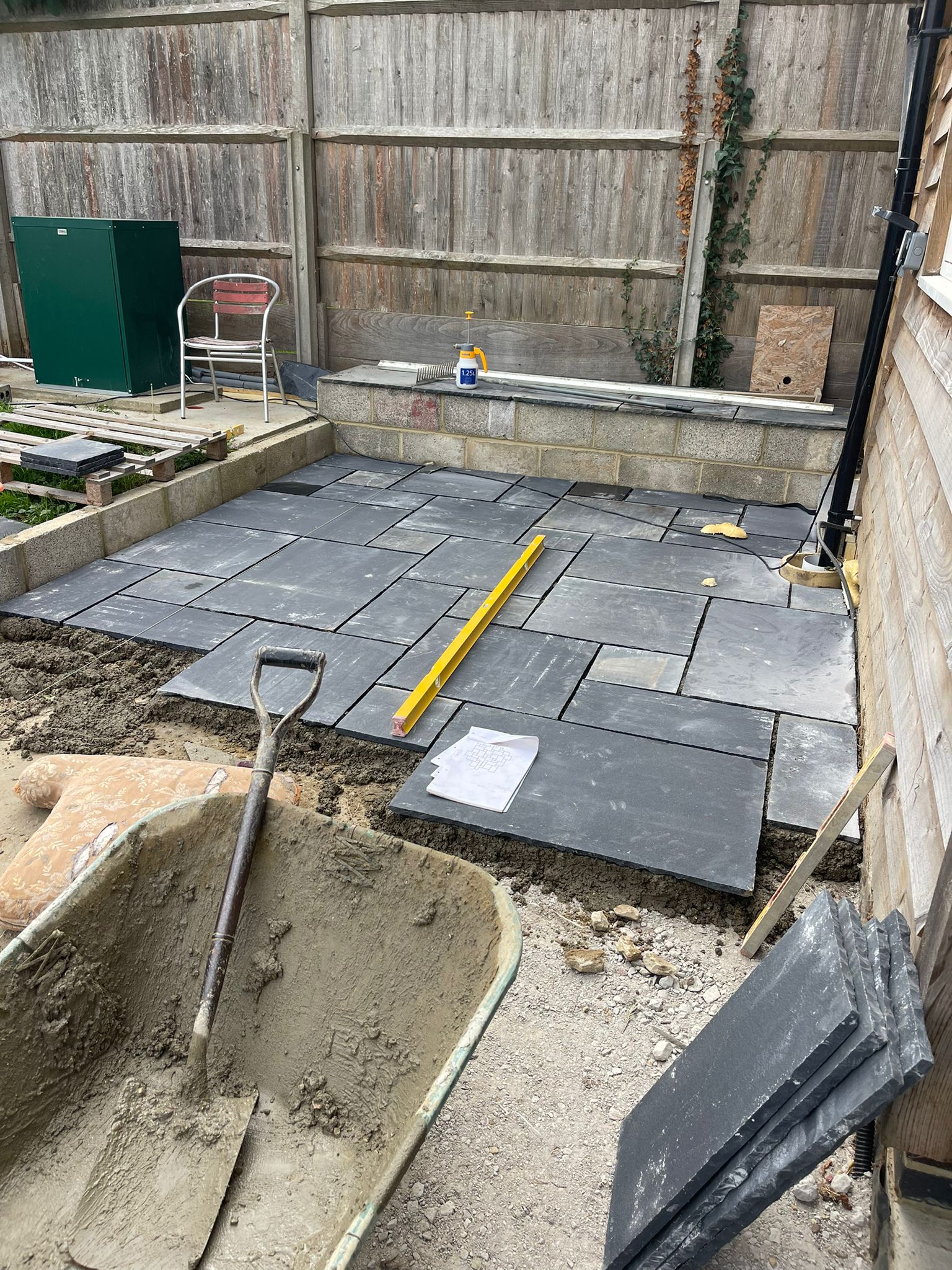 Dark slate patio slabs being laid