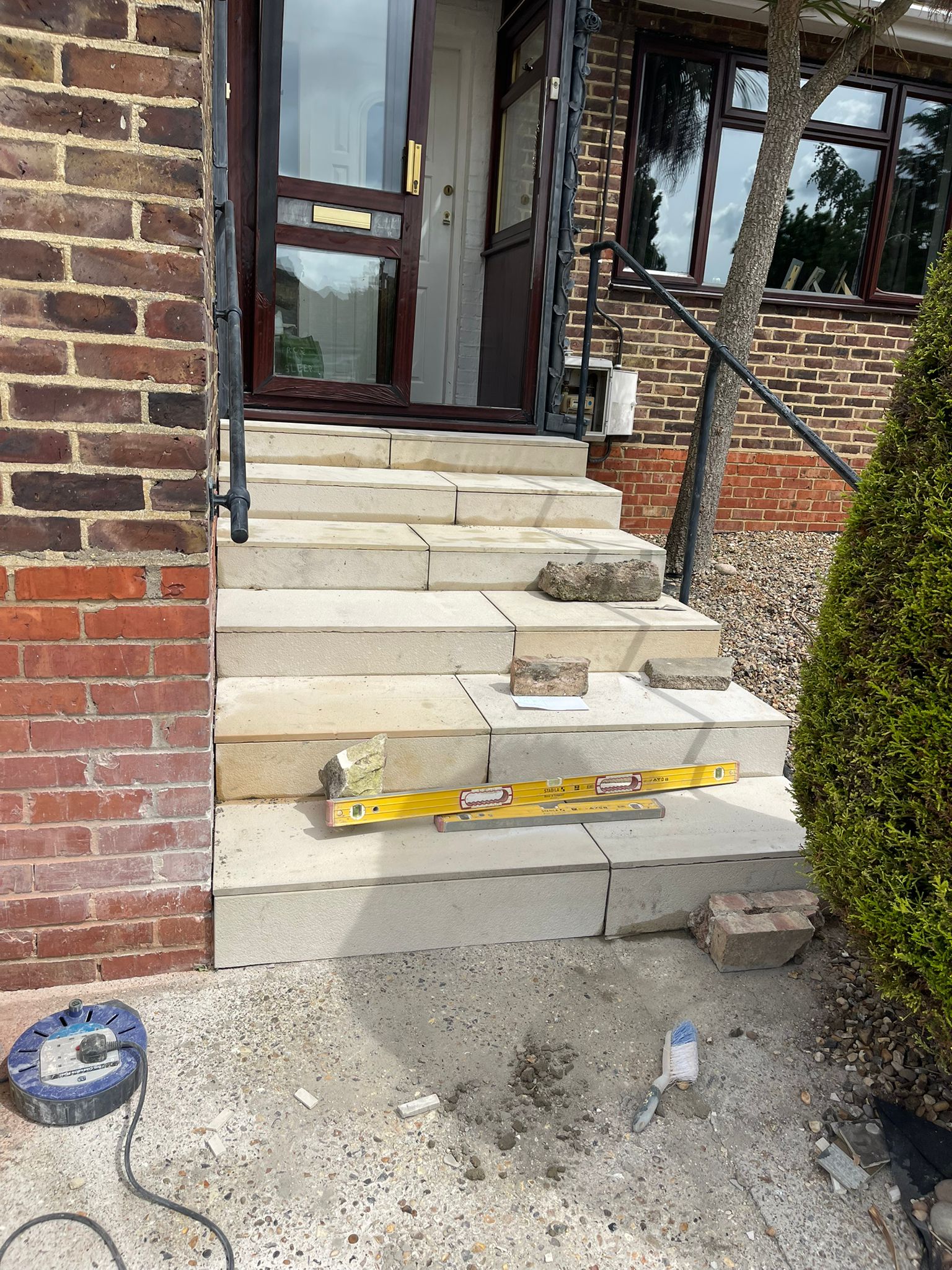 Natural stone front door steps with iron railings